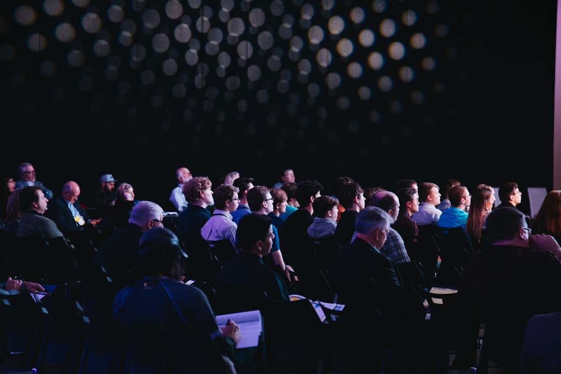 A keynote audience in a darkened conference hall