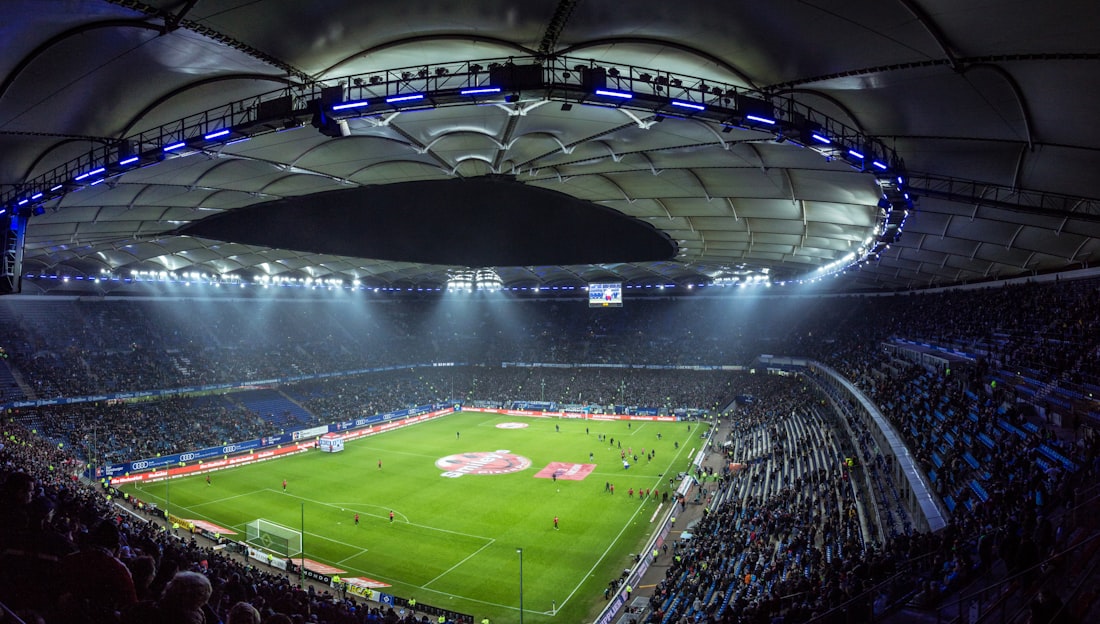 A packed stadium under floodlights at night